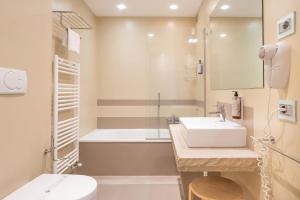 a bathroom with a sink and a tub and a toilet at The Ziba Hotel & Spa in Peschiera del Garda