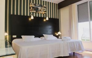 een slaapkamer met een groot bed met een zwart hoofdeinde bij HRC Hotel in Madrid