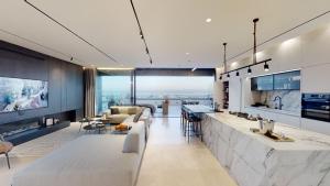 een keuken en een woonkamer met een aanrecht en een bank bij SERENE - Infinity Cview pool - 4 bedrooms Luxury Penthouse in Haifa