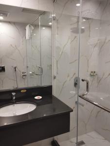 a bathroom with a sink and a glass shower at Avari Xpress Gilgit in Gilgit