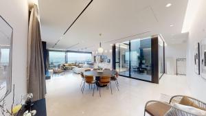een eetkamer en een woonkamer met een tafel en stoelen bij SERENE - Infinity Cview pool - 4 bedrooms Luxury Penthouse in Haifa