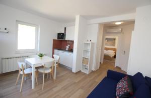 a living room with a table and a dining room at Apartman Milena in Punat