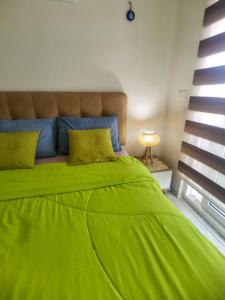 een groot groen bed in een kamer met een raam bij Cozy Sea view next to the beach, in the mid of the market, Saturday bazar, restaurants & bars etc, Alanya Mahmutlar! in Alanya