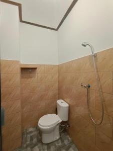 uma casa de banho com um WC e um chuveiro em Gending Sari House em Ubud
