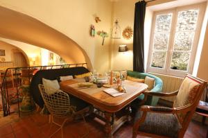 a dining room with a wooden table and chairs at La Treille Muscate in Cliousclat