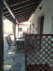 a patio with a table and chairs and a fence at Villa Nikos Koukounaries in Koukounaries