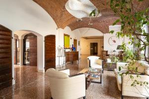 a living room with white furniture and a brick ceiling at The Ziba Hotel & Spa in Peschiera del Garda