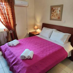 a bedroom with a pink bed with towels on it at Evaggelia's Private House in Fanes in Fánai