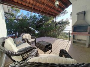 a patio with wicker chairs and an outdoor fireplace at Apartment Veroni in Sveta Nedelja