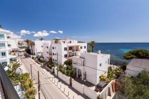 Blick auf eine Straße mit weißen Gebäuden und das Meer in der Unterkunft Apartamentos Bossa Bay - MC Apartamentos Ibiza in Ibiza-Stadt