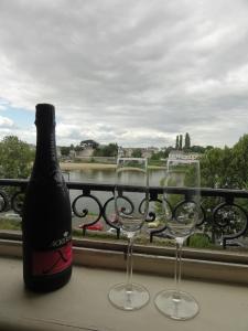 eine Flasche Wein und zwei Weingläser auf dem Balkon in der Unterkunft QUAI 2 in Saumur