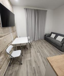 un soggiorno con divano, tavolo e sedie di Green Apartamentos Cartagena a Cartagena