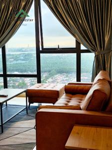 Habitación con sofás frente a una ventana grande. en Mosaic Southkey Midvelly By Elegant Johor Bahru, en Johor Bahru