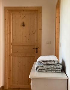 Habitación con puerta de madera y mesa con 2 mantas. en B&B Antico Fienile en Gorizia