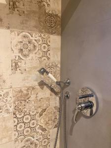 una ducha con una manguera pegada a la pared en B&B Antico Fienile en Gorizia