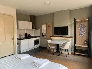 a room with two beds and a kitchen with a table at Plantage Hortus Apartments in Amsterdam