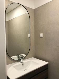 une salle de bain avec un lavabo et un grand miroir dans l'établissement Casa do Sul Guest House, à Lagos 6 autres photos