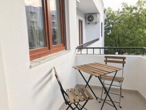une table en bois et deux chaises sur un balcon dans l'établissement Casa do Sul Guest House, à Lagos