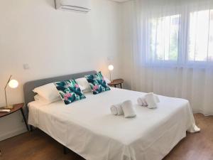 un lit blanc avec deux oreillers dessus dans l'établissement Casa do Sul Guest House, à Lagos