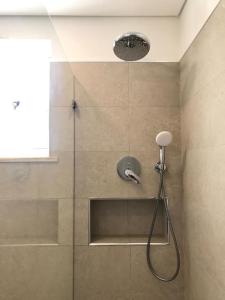 une douche avec pommeau de douche dans une salle de bain dans l'établissement Casa do Sul Guest House, à Lagos