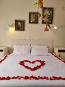 a bed with a heart made out of red roses at Neat standard room in guesthouse - 2088 in Bulawayo
