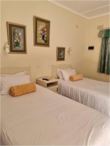 duas camas num quarto com lençóis brancos em Twin Room in Hillside - 2087 em Bulawayo