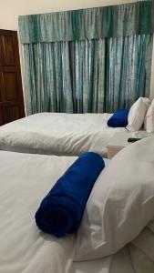 two beds with blue pillows on them in a bedroom at Twin Room in Hillside - 2087 in Bulawayo