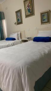 two beds in a hotel room with white sheets at Twin Room in Hillside - 2087 in Bulawayo