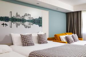 a hotel room with two beds and a painting on the wall at Mercure Swansea Hotel in Swansea