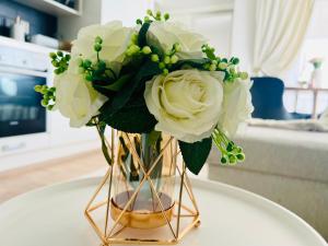 um vaso cheio de rosas brancas sobre uma mesa em Luxury of aristocrats near airport and jumbo em Vantaa