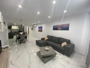 ein Wohnzimmer mit Sofa und Tisch in der Unterkunft Spacious Deluxe Seaside Escape in St Paul's Bay