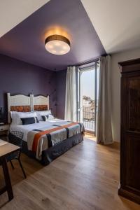 a bedroom with a large bed and a large window at Hotel Priori Secret Garden in Perugia