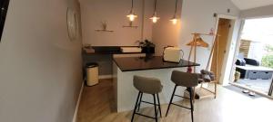 a small kitchen with a counter and two stools at Dean Clough Lodge - Contemporary self contained studio in Wilpshire