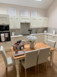 a kitchen with a wooden table and white cabinets at Strother's Townhouse in Berwick-Upon-Tweed +15 photos