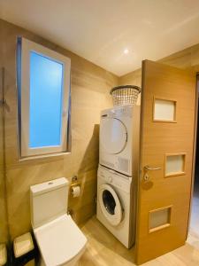a bathroom with a toilet and a washing machine at Large Seafront Maisonette in St Paul's Bay