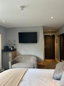 a bedroom with a bed and a flat screen tv at The Three Pickerels in Mepal