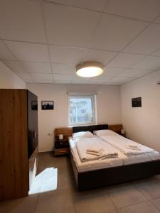 Un dormitorio con una cama grande y una ventana en AIS Center en Wolfsberg