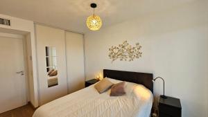- une chambre avec un lit et une lampe pendant dans l'établissement Arbre Blanc, une folie montpelliéraine, à Montpellier