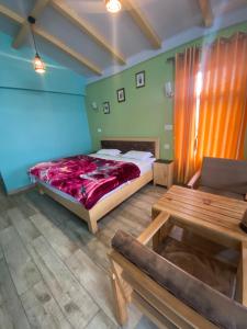 um quarto com uma cama e uma mesa em JAYANTI MOTHER NATURE HOMESTAY MUNSYARI em Munsyari