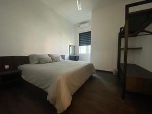 una camera da letto con un grande letto con lenzuola bianche di Casa Le View a Kuah