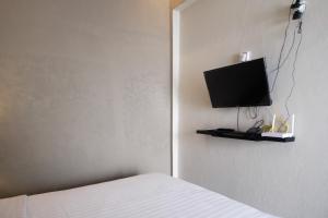 ein Schlafzimmer mit einem Bett und einem Fernseher an der Wand in der Unterkunft The Lavana Valvilla in Timuran