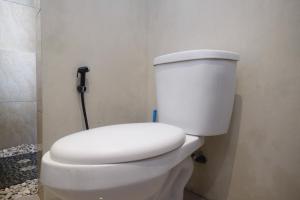 ein Badezimmer mit einer weißen Toilette in einem Zimmer in der Unterkunft The Lavana Valvilla in Timuran + 13 Fotos