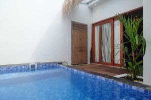 ein Pool vor einem Haus mit einer Tür in der Unterkunft The Lavana Valvilla in Timuran