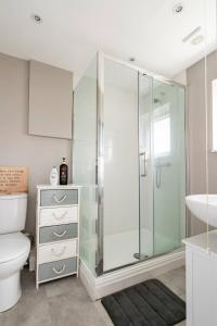 a bathroom with a shower and a toilet and a sink at Stevenage Contractors x8 New 3 bedroom House Free Wifi, Parking, Towels all inclusive & Large Garden in Stevenage