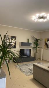 un soggiorno con TV a schermo piatto e piante di Casa Vacanza Latona R. a Casteldaccia
