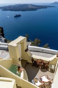 a view from the balcony of a house with a view of the ocean at Alma Libre Suites in Fira