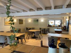 a restaurant with tables and chairs in a room at De Lanterfanters B&B 2.0 in Ramskapelle