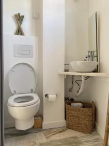 a bathroom with a white toilet and a sink at Lovers House in Setúbal
