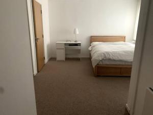 a bedroom with a bed and a desk with a lamp at Large Private Flat in City Centre Leeds in Leeds