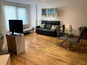 - un salon avec un canapé noir et une table en verre dans l'établissement Large Private Flat in City Centre Leeds, à Leeds